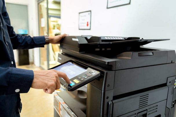 Zakenman Handdrukknop op printerpaneel, printer scanner laser kantoor kopieermachine levert startconcept. - Foto, afbeelding