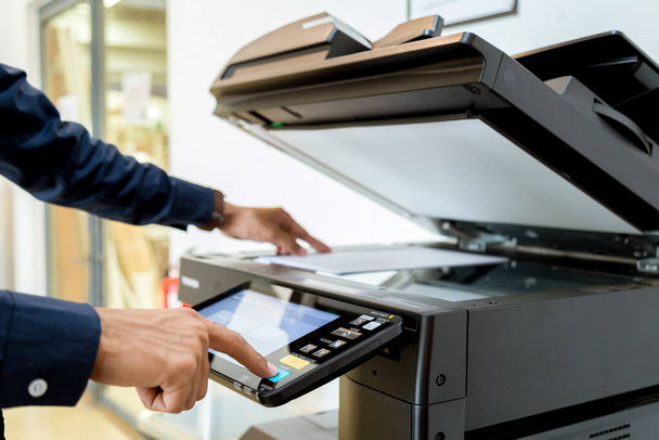 Bussiness man Hand press button on panel of printer, printer scanner laser office copy machine supplies start concept. - Фото, изображение