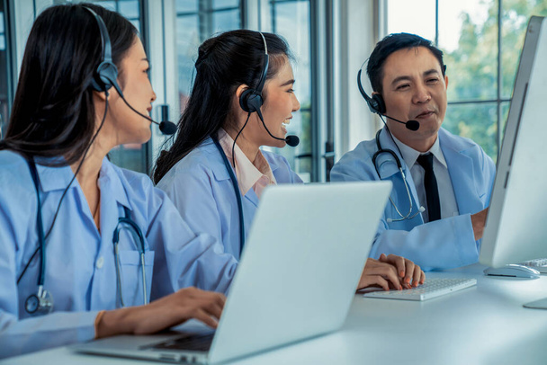 Lääkäri joukkue yllään kuulokkeet puhuu aktiivisesti videopuhelu sairaalassa klinikalla - Valokuva, kuva