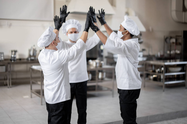 Wielorasowy zespół kucharzy daje pięć rąk przed pracą w kuchni - Zdjęcie, obraz