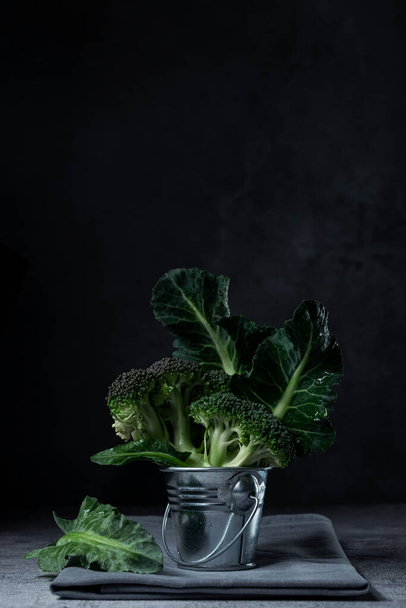 Broccoli crudi freschi in secchio. Buio umore, stile cibo chiaro come la luna. Spazio per testo - Foto, immagini