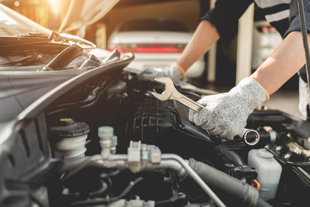 Otomobil tamircisi elleri ingiliz anahtarı, araba servisi ve bakımı ile bir araba motoru otomotiv atölyesini tamir ediyor.. - Fotoğraf, Görsel