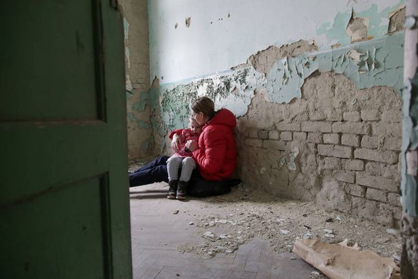 Madre e sua figlia nell'edificio distrutto. Guerra, rifugiati, concetto di crisi di guerra. - Foto, immagini