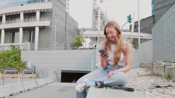 Yavaş çekim genç bayan dışarıda akıllı telefon web tarayıcı kullanarak gülümseyerek yeni para ticareti yapıyor. - Video, Çekim