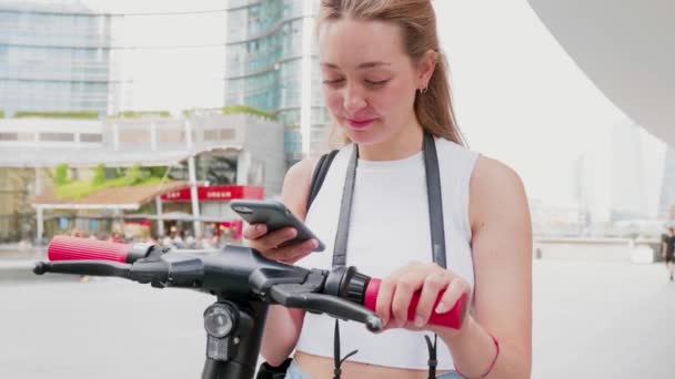 Lento movimento jovem mulher usando o código qr varredura smartphone desbloqueio chute scooter - Filmagem, Vídeo