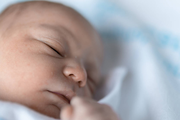 portré egy alvó újszülött arcáról és kis kezéről, órákkal a szülészeti kórházban. születés, új élet és jövőbeli koncepció. szelektív fókusz - Fotó, kép