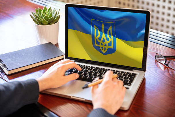 Apoya a Ucrania, dona ayuda al pueblo ucraniano. bandera en la pantalla del ordenador portátil. Escritorio de oficina de negocios fondo, 3d render - Foto, Imagen