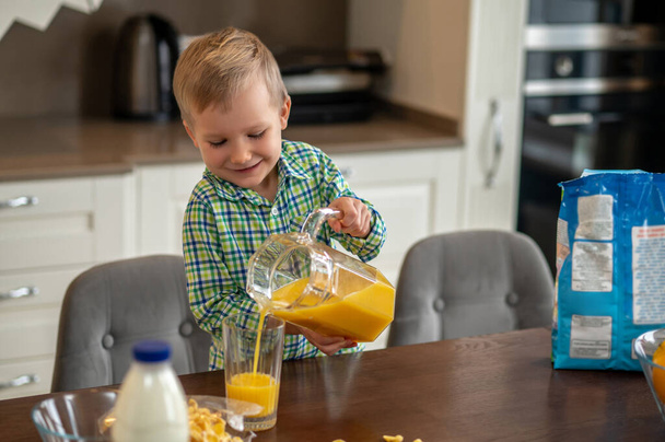 Child pouring a fruit juice from the jug - Zdjęcie, obraz