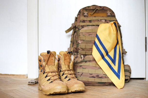 Fuerzas Armadas de Ucrania. Botas de soldado ucraniano, mochila y bandera. Bandera de Ucrania en uniforme militar. - Foto, imagen
