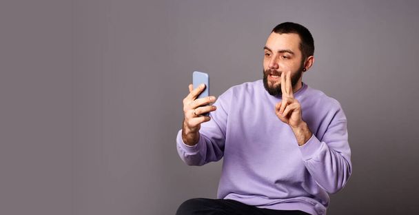 Hombre sosteniendo el teléfono inteligente en las manos, haciendo videollamada. Comunicación en línea. Grabación de vídeo o traducción de vida - Foto, imagen