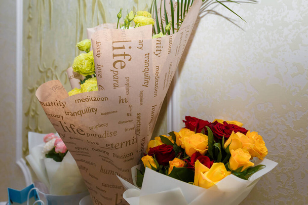 Hermosos ramos de rosas rojas, naranjas y amarillas en papel artesanal para cumpleaños o aniversario. - Foto, Imagen