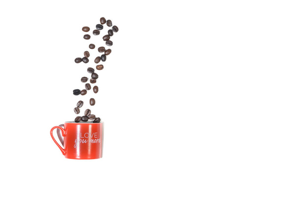 Roasted coffee beans popping out of the red cup on a white background. Overheat shot - Foto, Bild