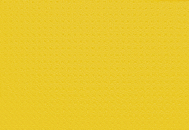 Porowaty żółty tło z kuchenny gąbka. Żółte tło wykonane z miękkiego materiału syntetycznego z chaotycznym zbliżeniem porów. Wolne miejsce na reklamy i tekst - Zdjęcie, obraz