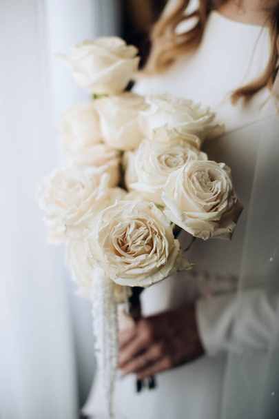 The bride holds a wedding bouquet of white roses - 写真・画像