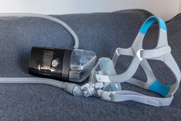 La máscara CPAP con una máquina de cpap de máscara facial completa contra la apnea obstructiva del sueño ayuda a los pacientes como máscara respiratoria y clip para el casco para respirar medicamentos en los ronquidos trastorno del sueño para respirar más fácil - Foto, imagen
