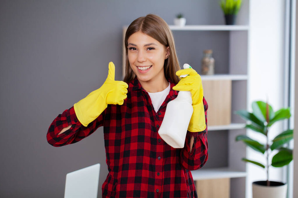 Jeune femme de ménage heureuse qui nettoie le bureau - Photo, image