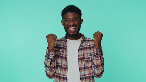 Afro-Amerikaanse man schreeuwt, heft vuisten in gebaar ik deed het, viert succes, wint - Foto, afbeelding