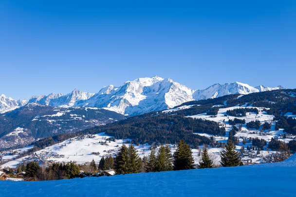 Tato fotografie krajiny byla pořízena v Evropě, ve Francii, Rhone Alpes, v Savojsku, v Alpách, v zimě. Vidíme zasněžený masiv Mont Blanc, pod sluncem. - Fotografie, Obrázek