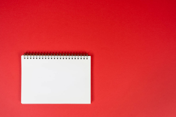 a blank spiral notebook on a red background - Zdjęcie, obraz
