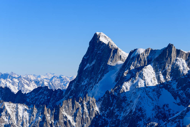 Αυτή η φωτογραφία τοπίου τραβήχτηκε στην Ευρώπη, στη Γαλλία, στο Rhone Alpes, στη Σαβοΐα, στις Άλπεις, το χειμώνα. Μπορούμε να δούμε το Les Grandes Jorasses, κάτω από τον ήλιο. - Φωτογραφία, εικόνα