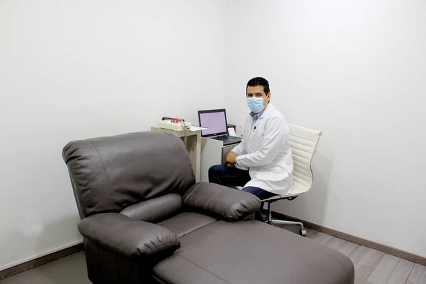 neurologo medico latino specialista in elettromiografia nervo e muscolo studio in ufficio bianco con poltrona - Foto, immagini