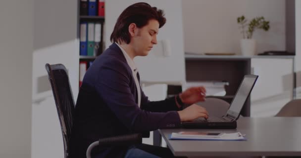 Tensed businessman using laptop in office - Footage, Video