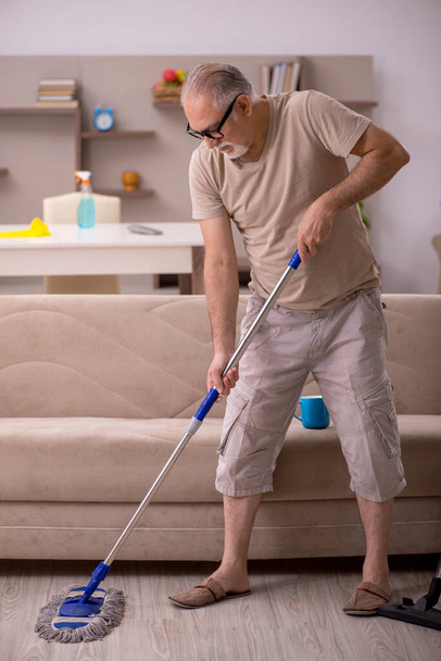 Alter Mann erledigt Hausarbeit zu Hause - Foto, Bild