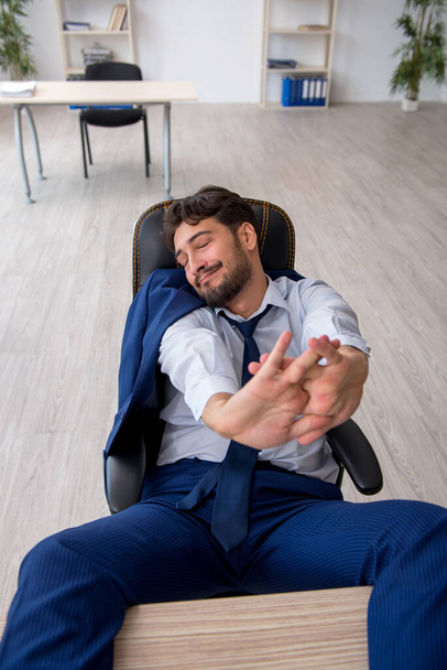 Joven empleado masculino extremadamente cansado en la oficina - Foto, Imagen