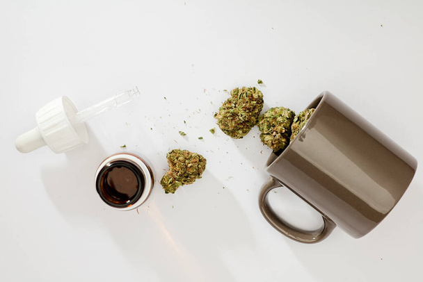 bourgeons de marijuana dans une tasse pour perfusion, compte-gouttes médicaux, sur fond blanc - Photo, image