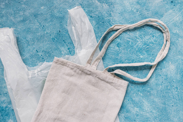 single use plastic bag next to reusable canvas one, plastic pollution and environmental awareness concept - Fotoğraf, Görsel