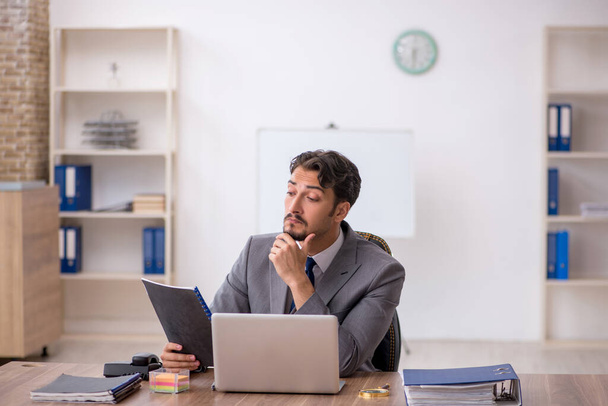 Joven empleado masculino sentado en la oficina - Foto, Imagen