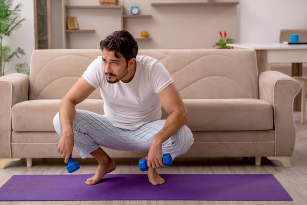 Young man doing sport exercises at home - Photo, Image