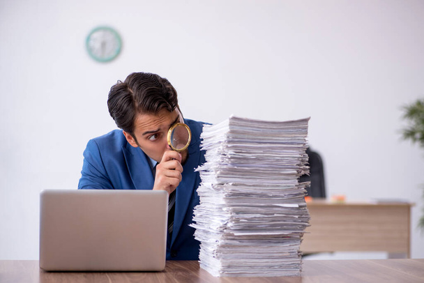 Joven empleado masculino descontento con el trabajo excesivo en la oficina - Foto, Imagen