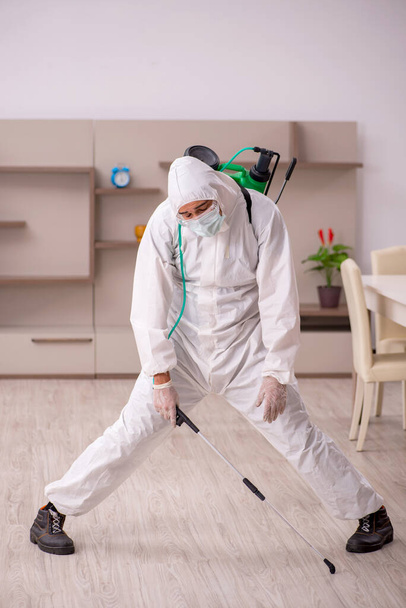 Joven contratista masculino haciendo control de plagas en casa - Foto, Imagen