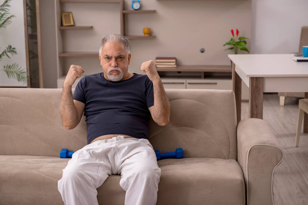Γέρος κάνει αθλητικές ασκήσεις στο σπίτι - Φωτογραφία, εικόνα