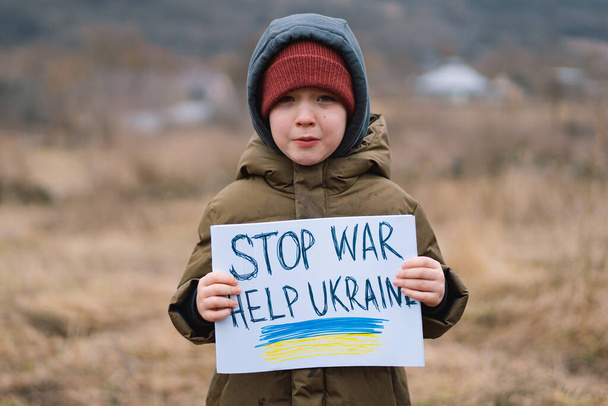 Πόλεμος της Ρωσίας εναντίον της Ουκρανίας. Κλάμα αγόρι ζητά να σταματήσει τον πόλεμο στην Ουκρανία. - Φωτογραφία, εικόνα