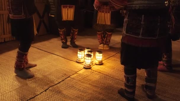Őslakos előadóművészet a turistáknak. Éjszaka halvány fény, Akha Hill törzsek, öltözött hagyományos jelmezek és gyönyörű díszek, tánc körül lámpások, lábak, és a láb együtt, ritmikusan. - Felvétel, videó