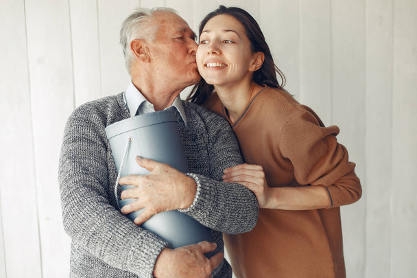 Elegant old man standing at home with his granddaughter - Fotoğraf, Görsel