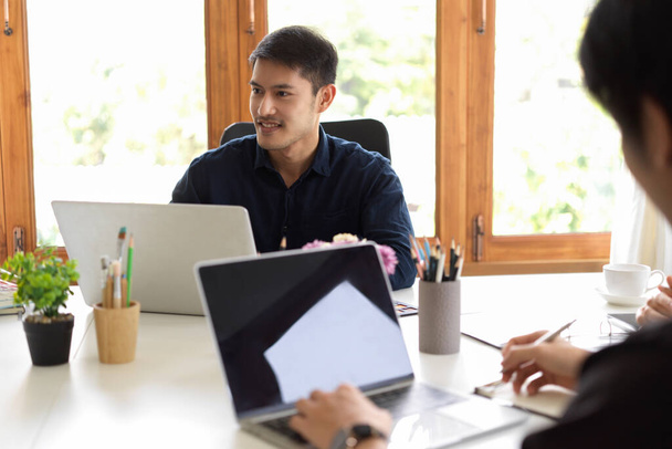 Gerente masculino asiático inteligente consultando con un equipo de asesores de inversión empresarial en la sala de reuniones. - Foto, imagen