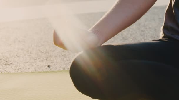 Close-up van de handen Aziatische vrouw zit in meditatie poseren positie yoga pranayama evenwicht in het prachtige uitzicht op het park tijdens zonsondergang. Gezondheid en welzijn. - Video