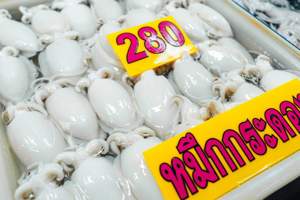 Свіжі кальмари в лотках для продажу на рибному ринку, ринок
 - Фото, зображення