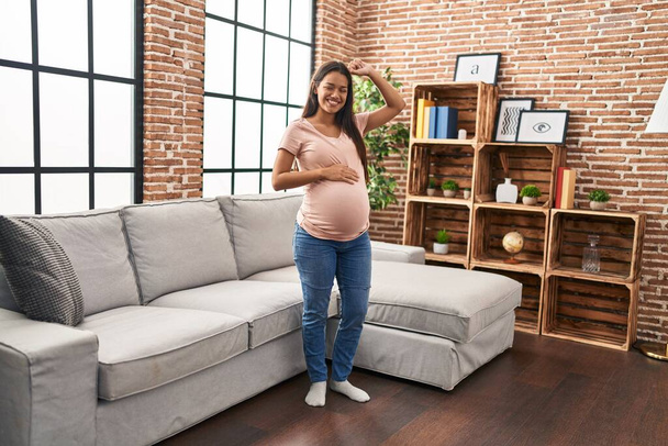 Молодая латиноамериканка, беременная, уверенно танцующая дома - Фото, изображение
