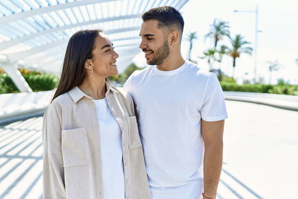 Jovem casal latino sorrindo feliz e abraçando a cidade. - Foto, Imagem