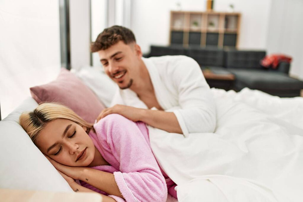 Mies herää tyttöystävänsä makaa sängyllä kotona. - Valokuva, kuva