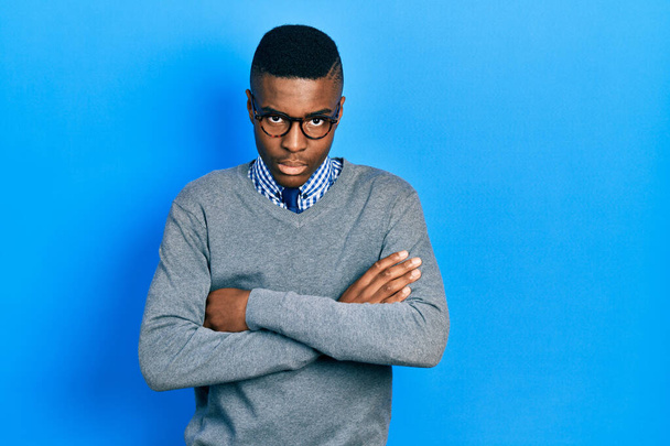 ビジネススタイルとメガネを身に着けている若いアフリカ系アメリカ人の男性は懐疑的で緊張し、両腕を組んで顔の表情を否定する。否定的な人.  - 写真・画像