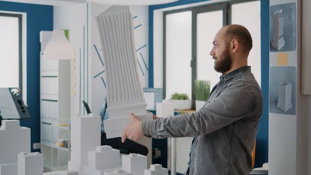 Hombre arquitecto analizando modelo de edificio y maqueta para diseñar propiedad urbana - Foto, Imagen