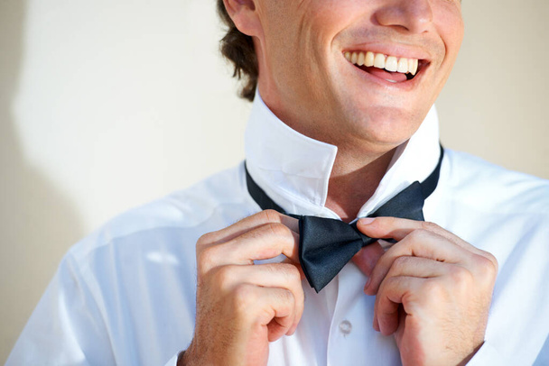 Налаштування краватки. Обрізане зображення щасливого чоловіка, що регулює краватку
. - Фото, зображення