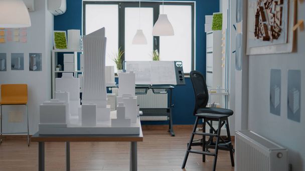 Prázdná technická kancelář s plánem výstavby nemovitostí a modelem budovy na stole - Fotografie, Obrázek