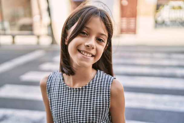 Young hispanic girl smiling outdoor at the town - Fotó, kép