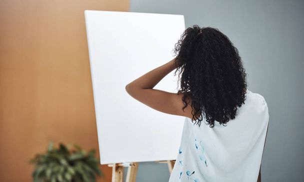 Творческий блок реален. Запись молодой женщины, выглядящей расстроенной, пытаясь рисовать дома на холсте. - Фото, изображение